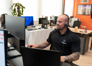 Student-support agent wearing a headset working at a computer station